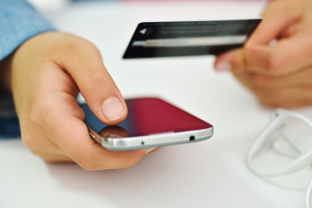 Hand-on-mobile-with-credit-card